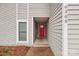 Inviting entryway with a vibrant red door nestled in a neutral-toned exterior, adding a pop of color at 6305 Hanna Ct, Charlotte, NC 28212