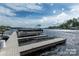 View of a dock with a pontoon boat in the foreground on a sunny day with a lake in the background at 8034 Bay Pointe Dr, Denver, NC 28037
