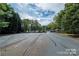 Driveway leading down to the lake with glimpses of boat docks and water through the trees at 8034 Bay Pointe Dr, Denver, NC 28037