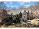 Aerial view of home showcasing a stone and brick exterior, landscaped front yard, and mature trees at 8034 Bay Pointe Dr, Denver, NC 28037