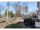 Large backyard featuring trees, a swing, patio furniture, and a fenced area at 1016 Helms Rd, Charlotte, NC 28214