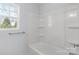 Bright bathroom featuring a shower-tub combination, a large window, and a sleek towel bar at 1016 Helms Rd, Charlotte, NC 28214