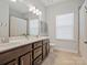 Bathroom with dual sink vanity, framed mirror, tiled floors, and natural light at 1016 Hickory Pine Rd, Waxhaw, NC 28173