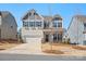 Charming two-story home boasts a well-manicured lawn, complemented by a paved driveway and attached garage at 1016 Hickory Pine Rd, Waxhaw, NC 28173