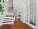 Elegant hallway showcases hardwood floors, a staircase, arched doorway, and decorative French doors at 1016 Hickory Pine Rd, Waxhaw, NC 28173