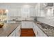 Bright, well-equipped kitchen with white cabinetry, granite countertops, and stainless steel appliances for cooking at 1016 Hickory Pine Rd, Waxhaw, NC 28173