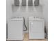 Bright laundry area equipped with white washer and dryer and wire shelving for storage at 1016 Hickory Pine Rd, Waxhaw, NC 28173