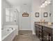 Elegant main bathroom with a glass shower, bathtub, and vanity with modern finishes at 1016 Hickory Pine Rd, Waxhaw, NC 28173