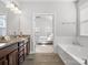 Bright main bathroom featuring a soaking tub, double vanity, and an open view to the main bedroom at 1016 Hickory Pine Rd, Waxhaw, NC 28173