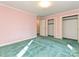 Bedroom with green carpet, pink walls, and large closets offering plenty of storage space at 1026 Norwich Rd, Charlotte, NC 28227