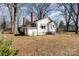 A view of a white home with a chimney and mature trees, showing the exterior charm and architectural details at 106 W 16Th St, Kannapolis, NC 28081