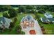 Aerial view of a brick home showcasing lush landscaping, large driveway, and mature trees at 109 Dabbling Duck Cir, Mooresville, NC 28117
