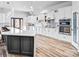 Open kitchen with white cabinets, stainless appliances, quartz countertops, pantry, and hardwood floors at 109 Dabbling Duck Cir, Mooresville, NC 28117