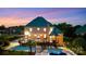Twilight image of home's rear exterior featuring a pool, deck, and fenced in backyard at 109 Dabbling Duck Cir, Mooresville, NC 28117