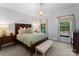 Calm bedroom with a dark wood bed frame, soft colors, and a bench seat under two windows at 1220 Broadside Rd, York, SC 29745