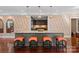 Spacious kitchen island featuring pendant lighting, orange stools, custom wallpaper and elegant hardwood floors at 1220 Broadside Rd, York, SC 29745