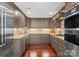 Updated kitchen boasts custom cabinetry, stainless steel appliances, tile backsplash, and hardwood floors at 1220 Broadside Rd, York, SC 29745