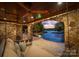 Outdoor living space overlooking the lake, featuring a stone archway, lounge area and wooden ceiling at 1220 Broadside Rd, York, SC 29745