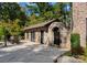 Stone pool house with a beautiful stone arched entry, tile patio, outdoor seating, and manicured landscaping at 1220 Broadside Rd, York, SC 29745
