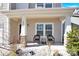 Cozy front porch showcasing stone-clad columns, complemented by comfortable seating, and manicured landscaping at 12852 Mustang Dr, Midland, NC 28107