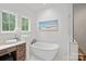 A luxurious bathroom featuring a standalone tub next to a window and a marble vanity with a bouquet of flowers at 1312 Portofino Pl, Davidson, NC 28036