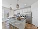 Bright kitchen with stainless steel appliances, white cabinets, an island, and pendant lighting at 13859 Hill St, Huntersville, NC 28078