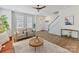 Bright living room with hardwood floors, a ceiling fan, neutral decor, and a staircase at 13859 Hill St, Huntersville, NC 28078