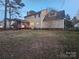 Large backyard view of the home and screened porch with a large grassy area at 1516 Plantation Trl, Gastonia, NC 28056