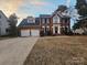 Charming brick home with attached two-car garage and manicured lawn at twilight at 1516 Plantation Trl, Gastonia, NC 28056