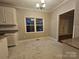 Eat-in kitchen featuring tile floors, white cabinets, and a window overlooking the backyard at 1516 Plantation Trl, Gastonia, NC 28056