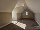 Attic room with neutral paint, carpet and small window, ready to be repurposed for a variety of uses at 159 S Gibbs Rd, Mooresville, NC 28117