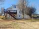 Wide shot of the back of the home with a wooden deck, stairs, and white siding at 159 S Gibbs Rd, Mooresville, NC 28117