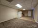 Basement with carpet and tile flooring with vintage kitchen cabinets and full-sized refrigerator at 159 S Gibbs Rd, Mooresville, NC 28117