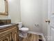 Bathroom featuring a toilet, vanity with marble countertop, and laminate flooring at 159 S Gibbs Rd, Mooresville, NC 28117