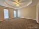 Bedroom with neutral carpet, tray ceilings, and windows allowing natural light at 159 S Gibbs Rd, Mooresville, NC 28117