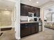 View of wet bar, stainless appliances, dark cabinets, and access to bathroom and bedroom at 1918 Ealand Ct, Waxhaw, NC 28173