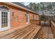 Wooden back deck of a brick home overlooking a green forest and landscaped backyard with two chairs at 201 Olive Rd, Stony Point, NC 28678