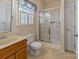 Bathroom with glass-enclosed shower, toilet, and vanity with shutters on the window at 201 Olive Rd, Stony Point, NC 28678