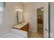 Bathroom with tub, vanity, and doorway leading to bedroom with carpet at 201 Olive Rd, Stony Point, NC 28678