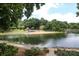 Scenic lake view showcasing lush trees, a sandy beach, and a tranquil body of water at 20115 Henderson Rd # D, Cornelius, NC 28031
