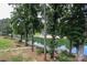 Scenic lake view showcasing lush trees, a sandy beach, and a tranquil body of water at 20115 Henderson Rd # D, Cornelius, NC 28031