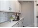 Butler's pantry with white cabinetry, countertop, and stylish backsplash is adjacent to a doorway at 2210 Camber Dr # Cwo0075, Gastonia, NC 28054