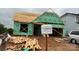View of a home under construction with green weather-resistant barriers, wooden framing, and a pile of lumber at 2210 Camber Dr # Cwo0075, Gastonia, NC 28054