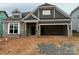 New construction exterior with gray siding, stone accents, and attached two-car garage at 2210 Camber Dr # Cwo0075, Gastonia, NC 28054