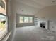 Unfinished living room featuring fireplace and built-in shelving with view of the yard in a new home at 2210 Camber Dr # Cwo0075, Gastonia, NC 28054