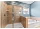 Bathroom featuring a glass-enclosed shower and a separate soaking tub with tile surround at 2439 Bergamot St, Fort Mill, SC 29708