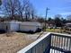 View of the backyard with detached garages, yard with trees, and a gray painted deck at 2507 Florida Ave, Kannapolis, NC 28083