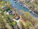Aerial view showcases this home's prime location on the waterfront among lush trees and a private driveway at 353 Whippoorwill Rd, Mooresville, NC 28117
