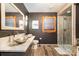 Modern bathroom with vessel sinks, floating vanity, tiled shower, and creative wood and stone accents at 353 Whippoorwill Rd, Mooresville, NC 28117