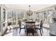 Sunlit dining room with large windows offering serene views, featuring a round wooden table and classic black dining chairs at 353 Whippoorwill Rd, Mooresville, NC 28117